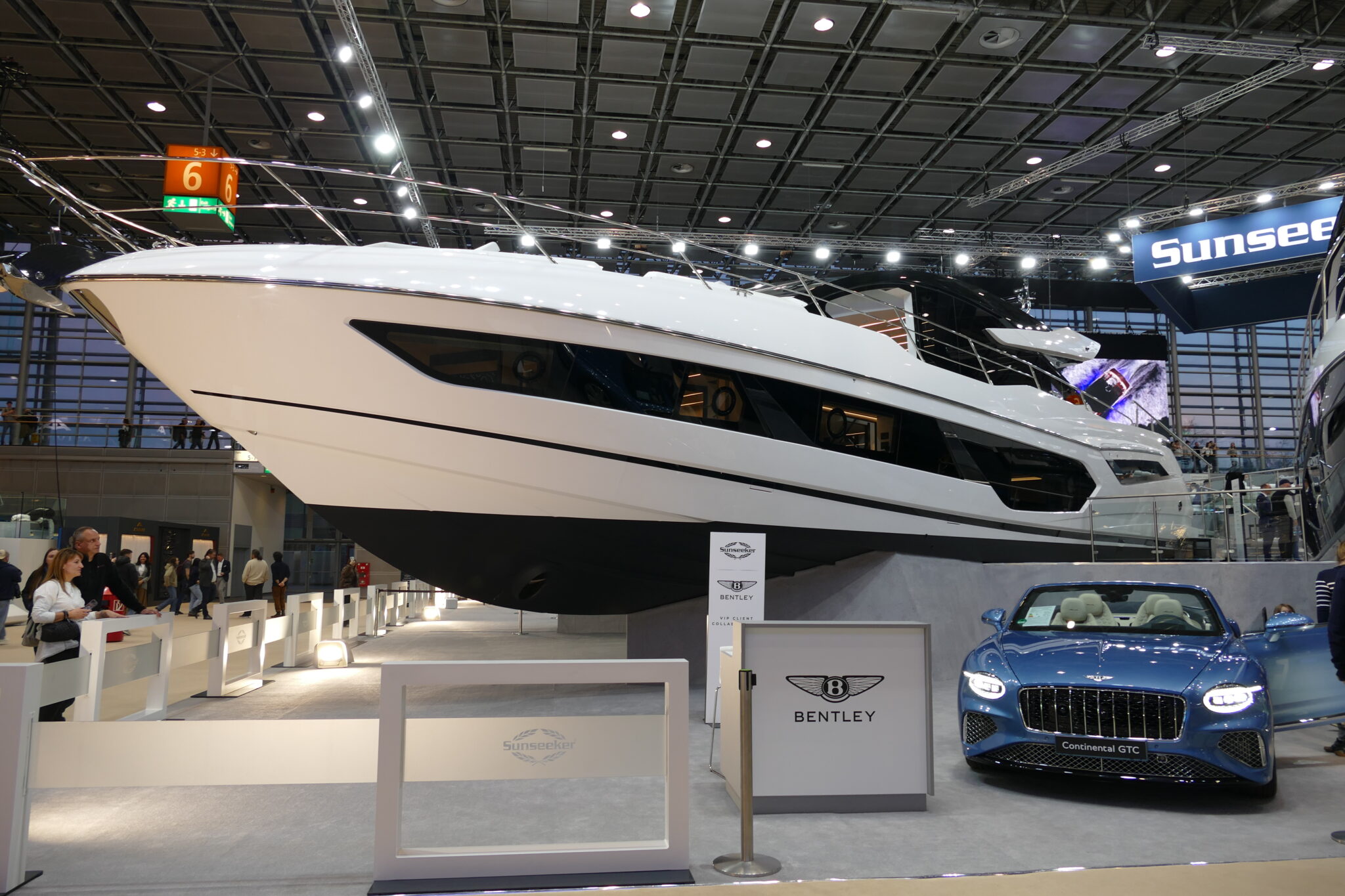 Eine Yacht von Bendley in weis mit dem passenden Auto in blau dazu.